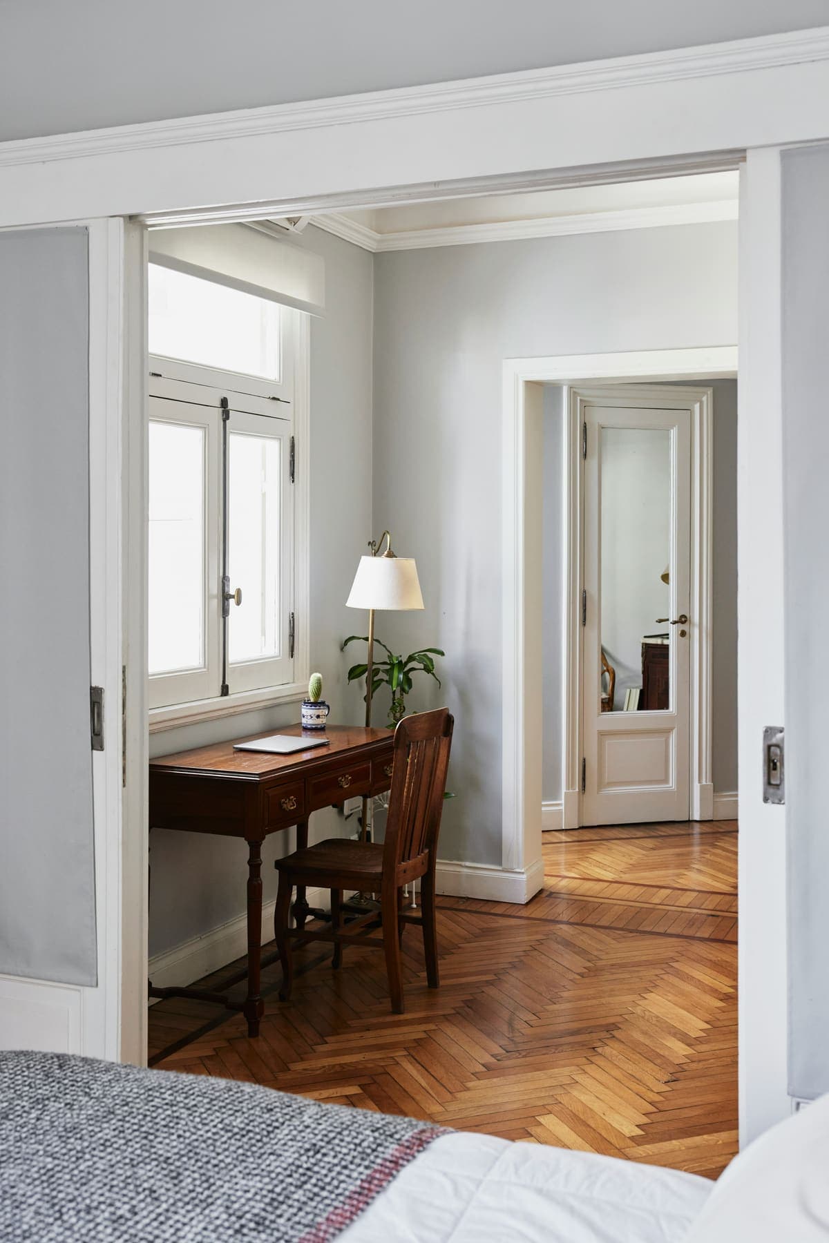 Antique writing desk and herringbone floor through architrave